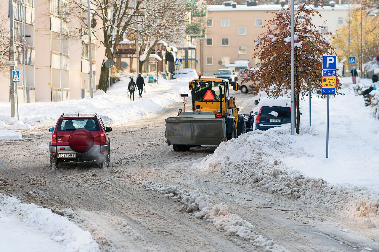 Snöig gata med plogbil